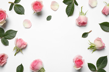 Frame made of beautiful flowers on white background, top view with space for text. Floral card design
