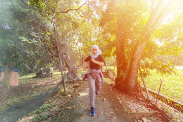 Malay Muslim lady wearing hijab outdoor running forward