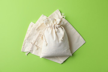 Cotton eco bags on light green background, flat lay