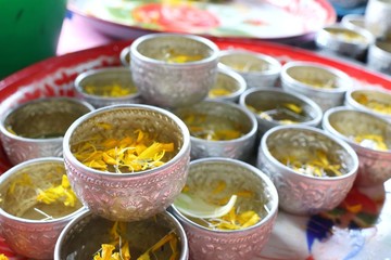 Marigold and Jasmine petal in samll silver bowl, Songkran festival in Thailand. Soft focus.