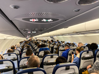 Cabin of a modern airplane filled with passangers to its full capacity during flight, after delayed departure (shallow DOF) © lightpoet