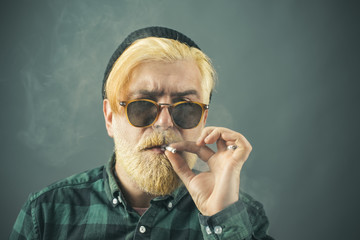 Head and shoulders portrait of a bearded middle-aged man looking thoughtfully at the camera over studio background with copy space.