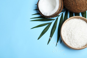 Flat lay composition with fresh coconut flakes on light blue background. Space for text