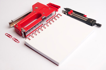 concept worktable design, compass, white notebook,2  stapler red,two click,on white background