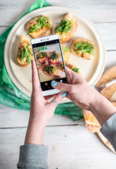 a person takes pictures with her phone, photographs healthy food