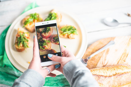 a person takes pictures with her phone, photographs healthy food