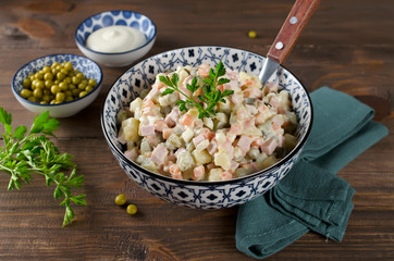 Russian traditional salad Olivier with vegetables and sausage