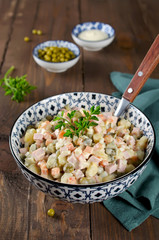 Russian traditional salad Olivier with vegetables and sausage