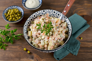 Russian traditional salad Olivier with vegetables and sausage