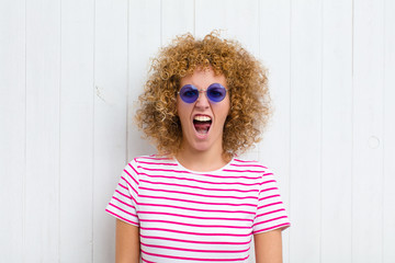 young pretty woman looking shocked, angry, annoyed or disappointed, open mouthed and furious