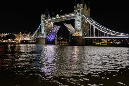 beautiful picture of the Tower Bridge in London at night with open gates for a big cruise ship, London, UK.