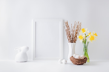 Home interior with easter decor. Mockup with a white frame and yellow daffodils in a glass vase on a light background