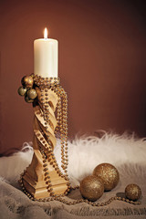 Candle light on a brown background with festive decorations