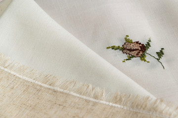 Close up view of the linen napkin with embroidery, piece of vintage calico