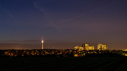 Germany, Magical starry sky over stuttgart city lights of skyscraper and tv tower illuminated by...