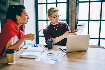 Fototapeta premium Young colleagues checking diagram in office
