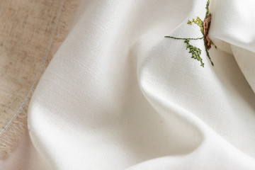 Close up view of the linen napkin with embroidery, piece of vintage calico