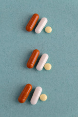 brown and white pill capsules on a blue background. Disease prevention. copy space