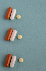 brown and white pill capsules on a blue background. Disease prevention. copy space