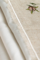 Close up view of the linen napkin with embroidery, piece of vintage calico