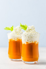 Carrot celery smoothie with coconut whipped cream. Selective focus, copy space.