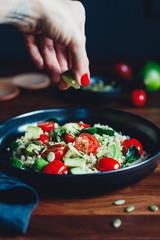 Healthy salad with bulgur, avocado, spinach and cherry tomatoes.