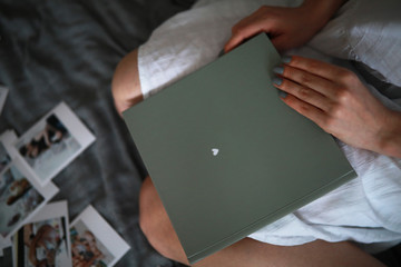 A woman holds a photo album in her hands.