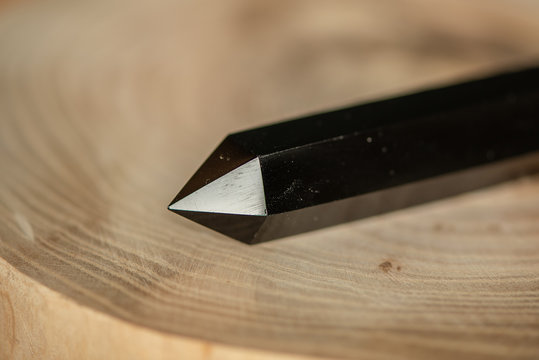 Black Obsidian Crystal On Wooden Background