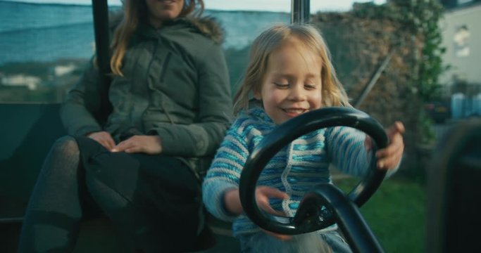 Happy little preschooler taking his mother for ride in playground car