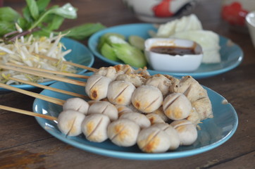 Many wooden meatballs on a blue plate
