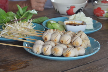 Many wooden meatballs on a blue plate