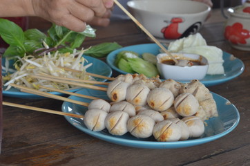 Many wooden meatballs on a blue plate