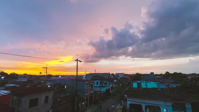 Skies turning bright orange in the horizon during sunset in the peaceful city of Dasmari&ntilde;as, Cavite, Philippines - Time lapse
