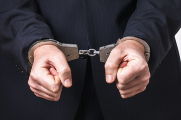 A man in a suit and handcuffs, close-up. Arrest Concept