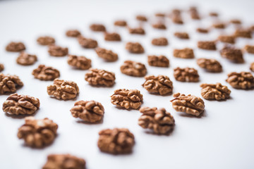 Pattern of walnuts on a white background.  Top view on a nuts pattern.