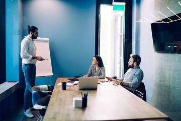 Confident team of colleagues talking about business presentation in office