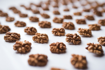 Pattern of walnuts on a white background.  Top view on a nuts pattern.