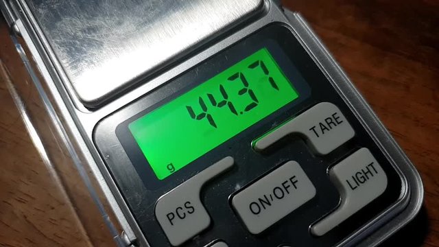 Pocket digital LCD precise scale in grams and ounces measuring and weighing ending in scary and ominous triple six number on the number digit display screen