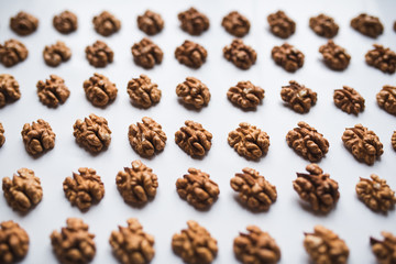 Pattern of walnuts on a white background.  Top view on a nuts pattern.