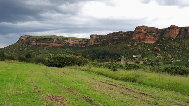 Moluti sandstone cliffs at the border of Lesotho in South Africa at the Camelroc travel guest farm, stunning clouds, most amazing mountains and green scenery landscapes