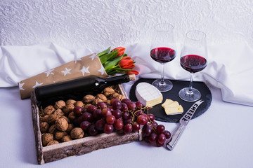glasses with wine, tulips and nuts lie on a tray