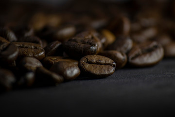 Coffee in beans on dark background. Abstract background texture.Coffee beans texture. Food background of coffee beans