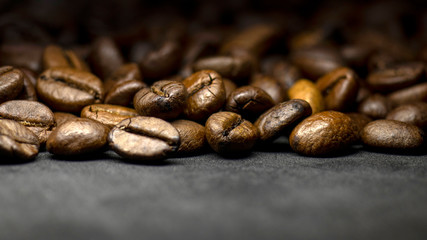 Coffee in beans on dark background. Abstract background texture.Coffee beans texture. Food background of coffee beans