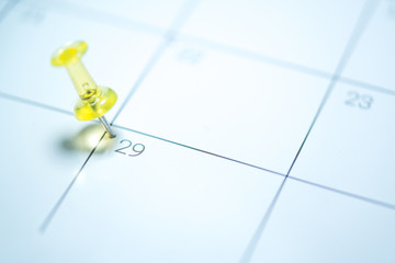 Yellow push pin on calendar 29th leap year day of the month