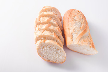 Freshly baked French baguettes on white wooden table.