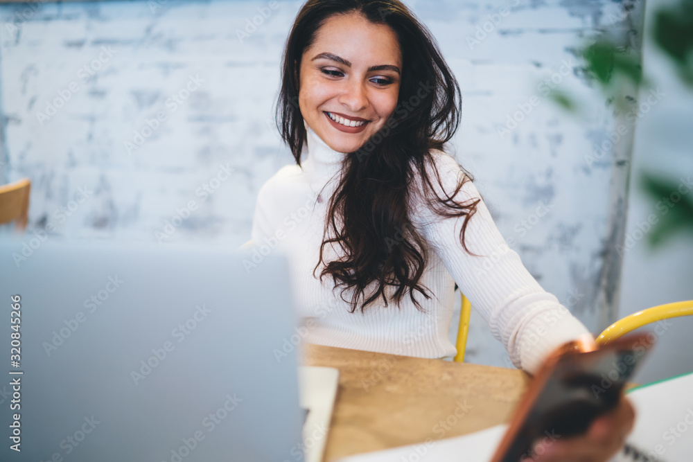 Aufkleber cheerful woman 20s browsing wireless website during networking via smartphone device, smiling caucas