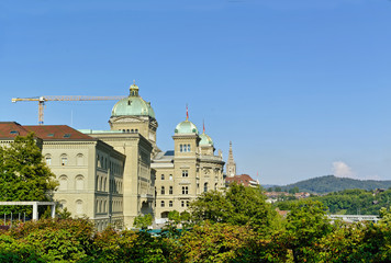 The Swiss parliament building (Bundeshaus) in Bern, with Cathedral in the background, in sunny summer afternoon.