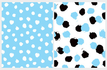 Fototapeta premium Set of 2 Cute Abstract Dots Vector Pattern. White, Blue and Black Irregular Brush Dots on a White and Blue Backgrounds. Lovely Pastel Color Geometric Prints for Fabric, Textile, Wrapping Paper.