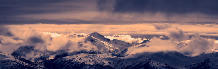 Fototapeta na wymiar Whistler, British Columbia, Canada. Beautiful Panoramic View of the Canadian Snow Covered Mountain Landscape during a cloudy and vibrant winter sunset. Black and White Art Tint