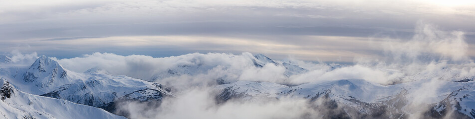 Whistler, British Columbia, Canada. Beautiful Panoramic View of the Canadian Snow Covered Mountain Landscape during a cloudy and vibrant winter sunset.
